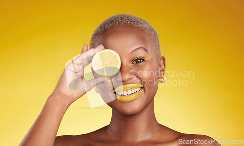 Image of Happy black woman, portrait and lemon for vitamin C or natural beauty against a yellow studio background. African female person smile with organic citrus fruit for diet or detox with facial makeup