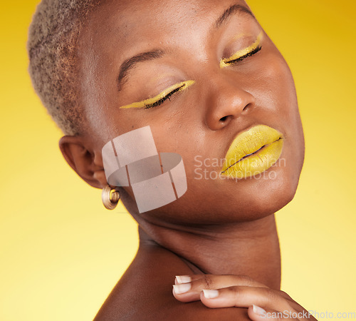 Image of Cosmetic, art and woman in a studio with makeup eyeliner and lipstick for cosmetology. Beauty, creative and young African female model with a colorful glamour face routine by a yellow background.