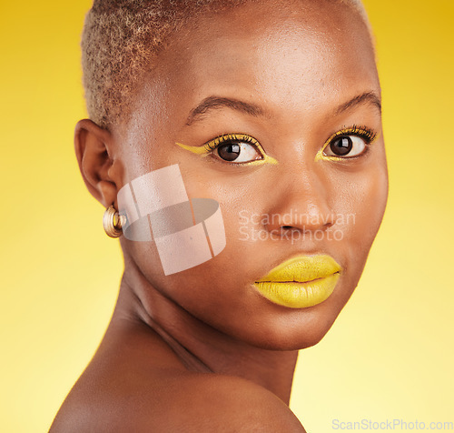 Image of Beauty, makeup and portrait of a woman in a studio with eyeliner and lipstick for cosmetology. Self care, cosmetic and young African female model with a colorful face routine by a yellow background.