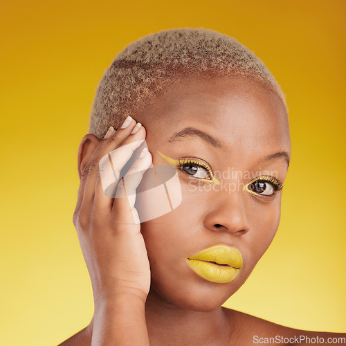 Image of Portrait, cosmetics and african girl with creative for glow in yellow studio with background in closeup. Woman, serious and skincare with bright makeup with hand on face for dermatology or wellness.