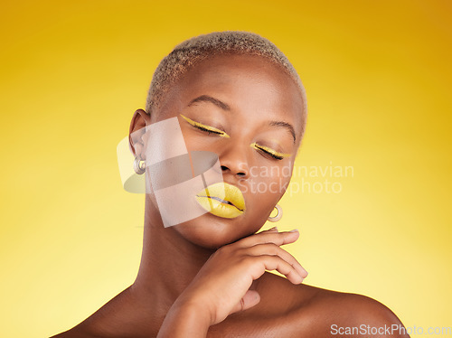 Image of Face, makeup and lipstick with a black woman in studio on a yellow background for creative, beauty or cosmetics. Gold, color and eyeshadow on young model with eyes closed for fashion or aesthetic