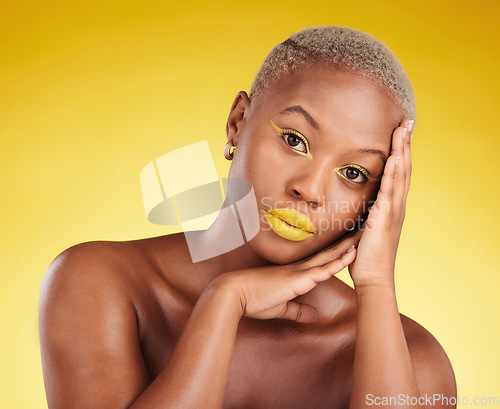 Image of Cosmetics, glow and african girl in portrait for skincare in yellow studio or gold background for facial. Woman, serious and hand on face with makeup for spa treatment for dermatology or wellness.