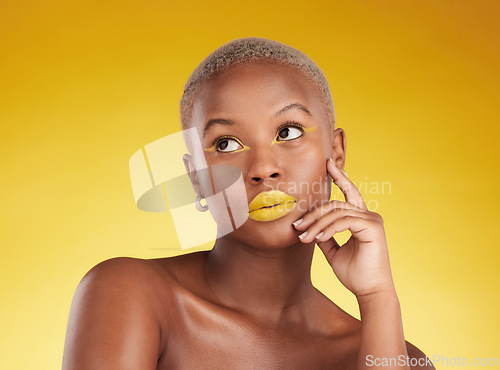 Image of Thinking, makeup and a black woman on a studio background for creativity or fashion. Ideas, gold art and an African girl or model with yellow lipstick, cosmetics or young beauty on a backdrop