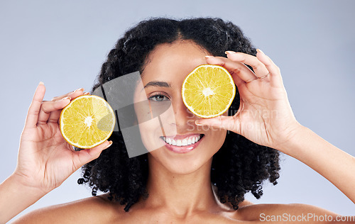 Image of Girl, skincare and lemon eye for wellness in portrait for natural beauty in grey studio background. Happy face, hand and vitamin c with woman for dermatology or facial treatment for diet or care.