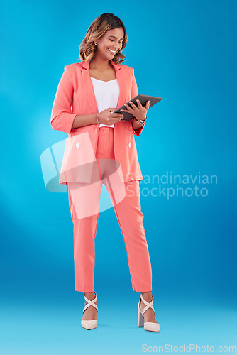 Image of Smile, reading and a woman with a tablet on a blue background for communication, email or the web. Happy, corporate and a young Indian girl with typing on technology for work, internet or business