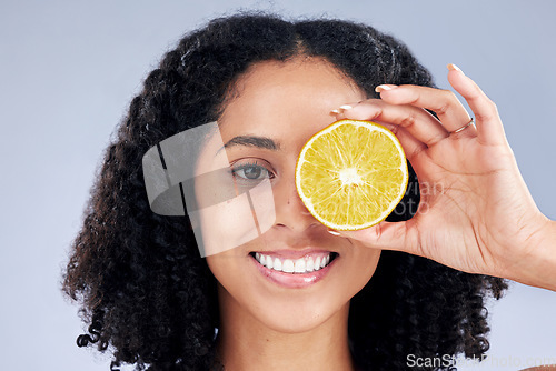 Image of Skincare, smile and lemon eye for nutrition or fruit with glow in grey studio background. Female person, portrait and vitamin c or natural with facial treatment and organic food for dermatology.