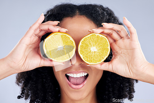 Image of Woman, lemon eyes and wellness in studio with comic smile, health and skincare with nutrition by background. Girl, model and fruit for diet, cleaning or cosmetics with beauty, self care and emoji