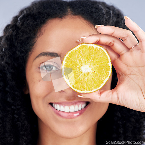 Image of Portrait, wellness and woman with lemon eye for nutrition in closeup in grey studio background. Skincare, girl and vitamin c for facial treatment with natural organic food for dermatology or fruit.