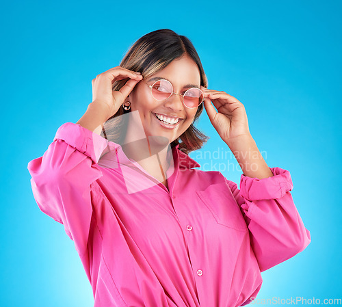 Image of Fashion sunglasses, portrait and happy woman in studio isolated on a blue background. Face, glasses and Indian model with style, designer shades and positive mindset for aesthetic, gen z and smile