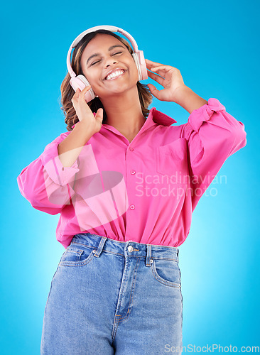 Image of Young woman, headphones and music, audio streaming service and techno or student podcast in studio. Happy person listening to radio with gen z electronics and wellness on a blue, gradient background