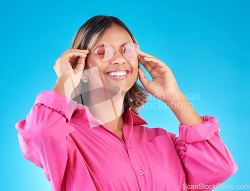 Image of Fashion sunglasses, portrait and woman smile in studio isolated on a blue background. Face, glasses and Indian model with style, designer shades and positive mindset for aesthetic, gen z and happy