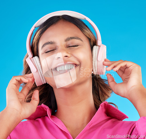 Image of Headphones, happy music and woman or student with streaming service with mental health podcast in studio. Young african person listening to radio, electronics and audio technology on blue background