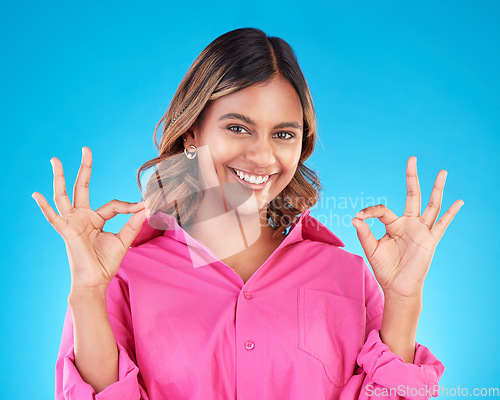 Image of Woman, hands and OK sign with portrait, agreement and positive feedback vote isolated on blue background. Happy female person, like emoji and success with support, hand gesture and review in studio