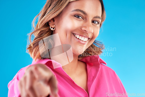 Image of Woman, pointing finger and smile portrait in studio for beauty, advertising and choice. Face of a happy model person with hand or emoji for accountability, decision or choosing you on blue background