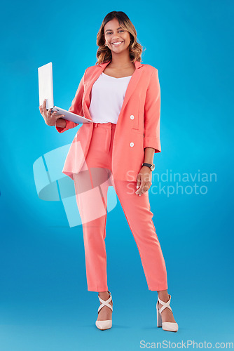 Image of Computer, fashion and business woman for online marketing, social media planning or copywriting portrait in studio. E commerce, designer suit and full body of person on a laptop and blue background