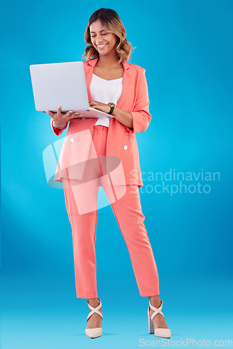 Image of Laptop, fashion and business woman with online marketing, social media planning or copywriting research in studio. E commerce, creative suit and full body of person on a computer and blue background