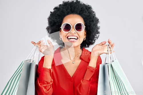 Image of Happy black woman, face and shopping bags for fashion or style against a white studio background. Portrait of African female person, customer or shopper smile for discount, sale or deal in happiness