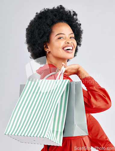 Image of Shopping bag, happy portrait and woman with fashion discount, sale and retail promotion on a white background. Gift, giveaway and young customer, model or african person with clothes in studio