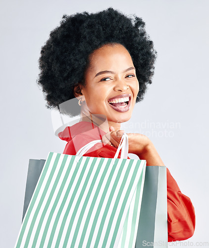 Image of Shopping bag, portrait and woman excited for fashion discount, cosmetics sale in retail on a white background. Gift, beauty giveaway and young customer, model or african person laughing in studio