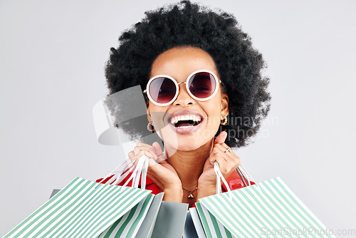 Image of Happy black woman, face and shopping bags for fashion or style against a white studio background. Portrait of African female person, customer or shopper smile for discount, sale or deal in happiness