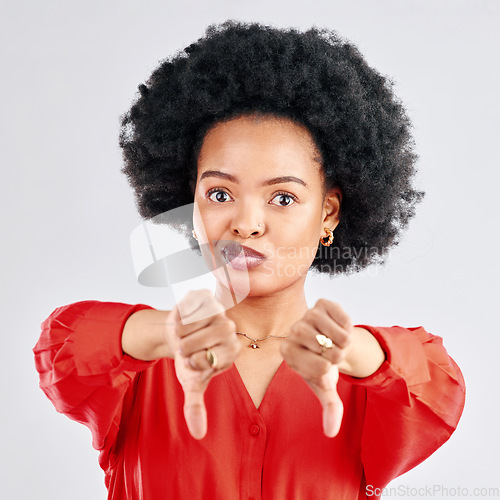 Image of Thumbs down, portrait and hands of black woman in studio reject bad news, emoji sign and feedback on white background. Face of female model show negative review, wrong decision or vote no for failure