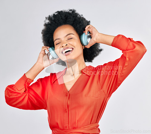 Image of Black woman, headphones and happy music in studio for podcast subscription on white background. Face, freedom and female model smile while listening to audio, streaming sound or hearing song on radio