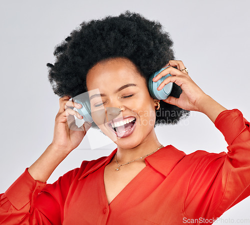 Image of Excited black woman, music and headphones in studio for podcast subscription on white background. Face of happy female model singing while listening to audio, streaming sound or hearing song on radio