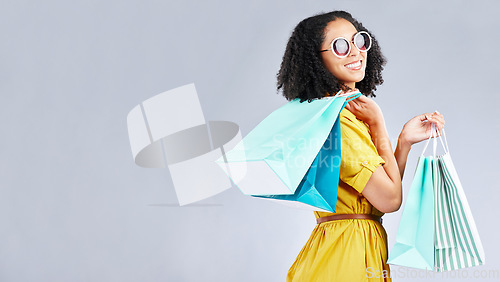 Image of Woman, shopping and excited with bags at retail sale, promotion or happy for discount on studio, mockup or background. Customer, portrait and shop for fashion or sales on luxury clothing