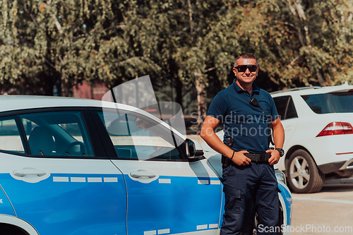 Image of A policeofficer patrols the city. A police officer with sunglasses patroling in the city with an official police car