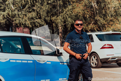 Image of A policeofficer patrols the city. A police officer with sunglasses patroling in the city with an official police car