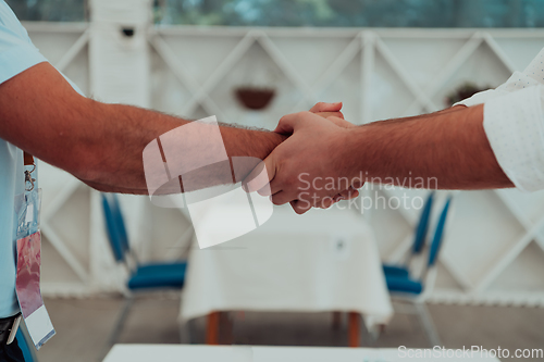 Image of Close up a handshake, businessman together creates a mutually beneficial business relationship. The economic graph on the table