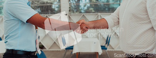 Image of Close up a handshake, businessman together creates a mutually beneficial business relationship. The economic graph on the table