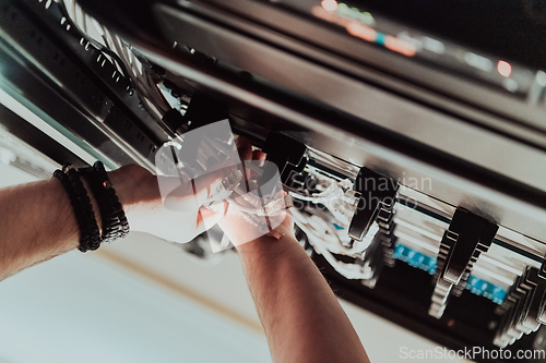 Image of Close up of technician setting up network in server room