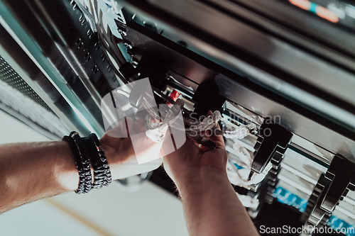 Image of Close up of technician setting up network in server room