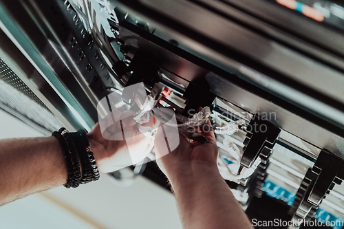 Image of Close up of technician setting up network in server room