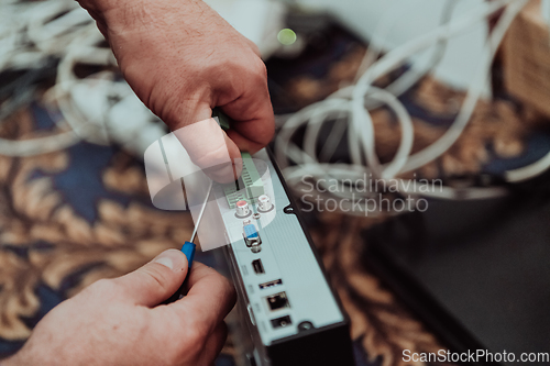 Image of Repairing a technical device. A repairman repairs a broken device