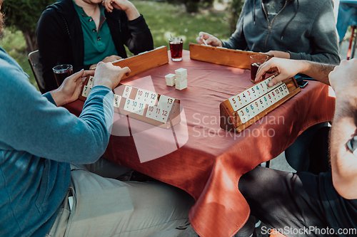 Image of A group of men drink traditional Turkish tea and play a Turkish game called Okey