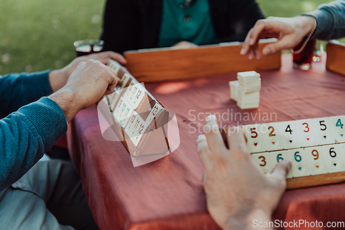 Image of A group of men drink traditional Turkish tea and play a Turkish game called Okey