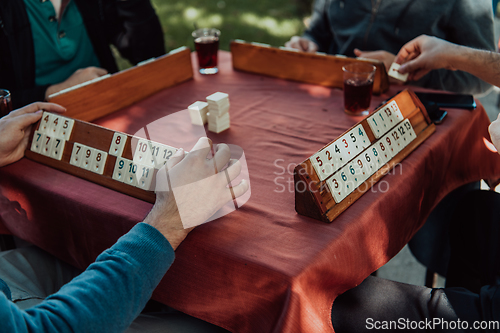 Image of A group of men drink traditional Turkish tea and play a Turkish game called Okey