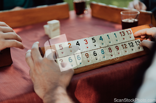 Image of A group of men drink traditional Turkish tea and play a Turkish game called Okey