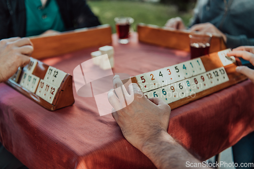 Image of A group of men drink traditional Turkish tea and play a Turkish game called Okey