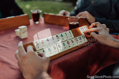 Image of A group of men drink traditional Turkish tea and play a Turkish game called Okey