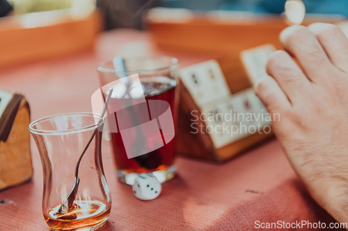 Image of A group of men drink traditional Turkish tea and play a Turkish game called Okey