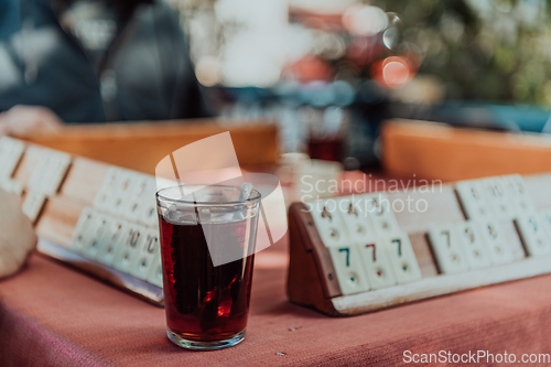 Image of A group of men drink traditional Turkish tea and play a Turkish game called Okey