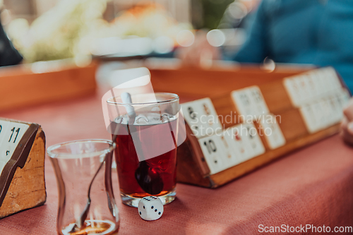 Image of A group of men drink traditional Turkish tea and play a Turkish game called Okey