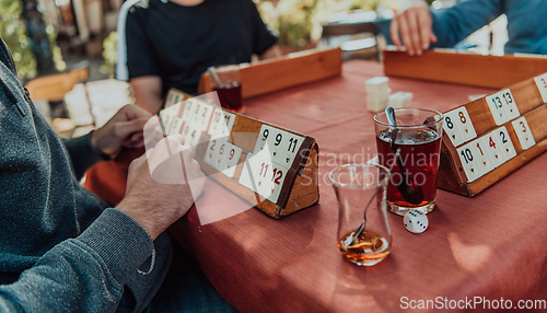 Image of A group of men drink traditional Turkish tea and play a Turkish game called Okey