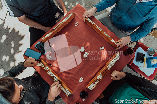 Image of A group of men drink traditional Turkish tea and play a Turkish game called Okey