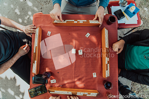 Image of A group of men drink traditional Turkish tea and play a Turkish game called Okey