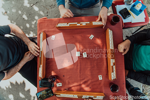 Image of A group of men drink traditional Turkish tea and play a Turkish game called Okey