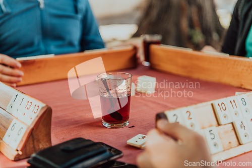 Image of A group of men drink traditional Turkish tea and play a Turkish game called Okey